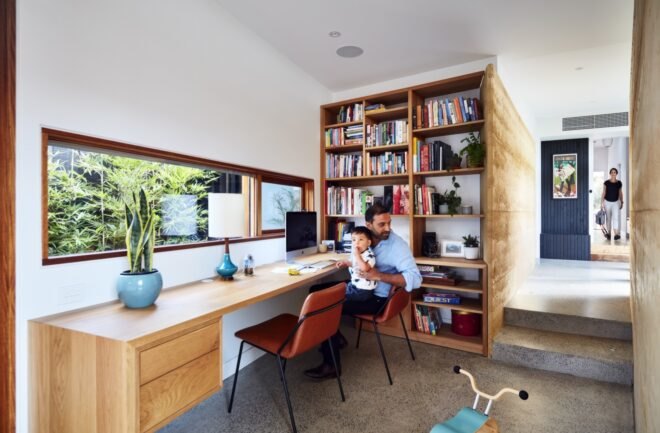 father sitting at a desk and holding a child