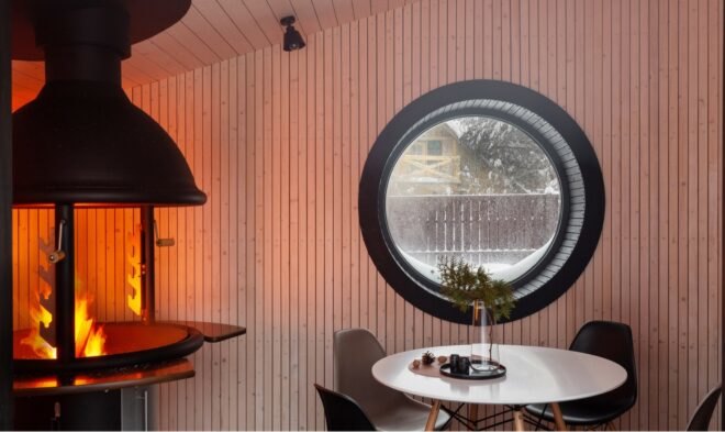 interior of tiny home with small rounded window near round dining table