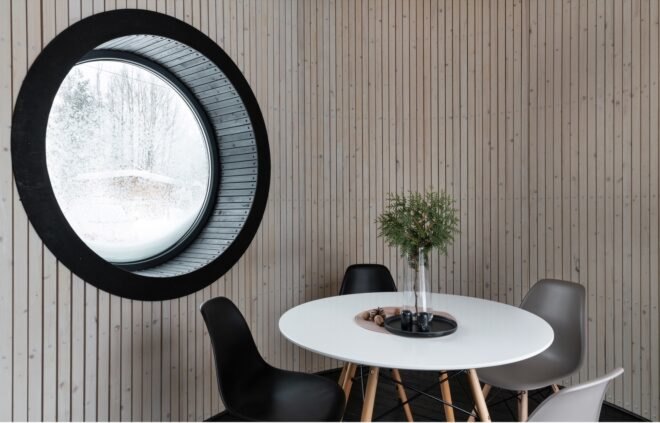 interior of tiny home with small rounded window near round dining table