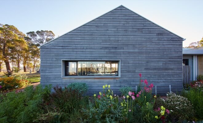 farmhouse with gray timber siding and gabled roof