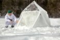 man crafting together a frozen geodesic dome