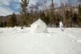 man walking toward geodesic ice igloo