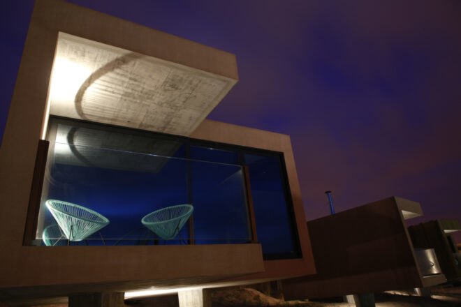 wooden hotel building with glass facade at night