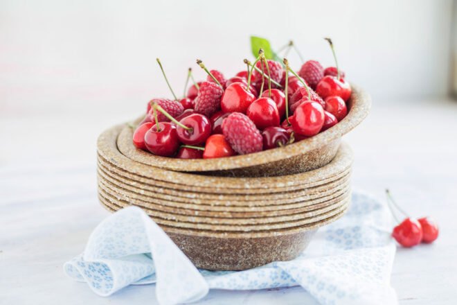 brown biodegradable tableware with bright cherries on plate