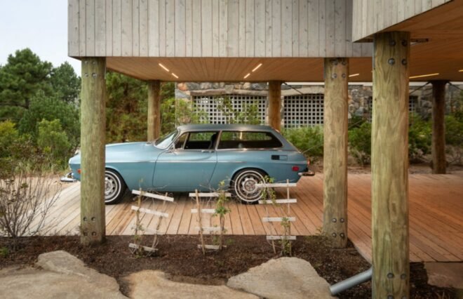 classic car parked under home on stilts