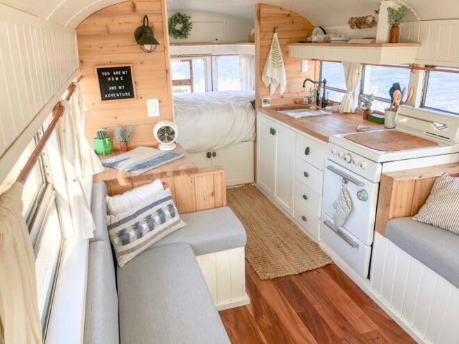 white kitchen with wood counters next to gray couch