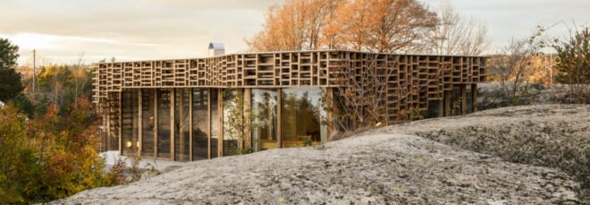 home wrapped in timber slats on rocky landscape