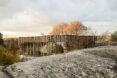 home wrapped in timber slats on rocky landscape