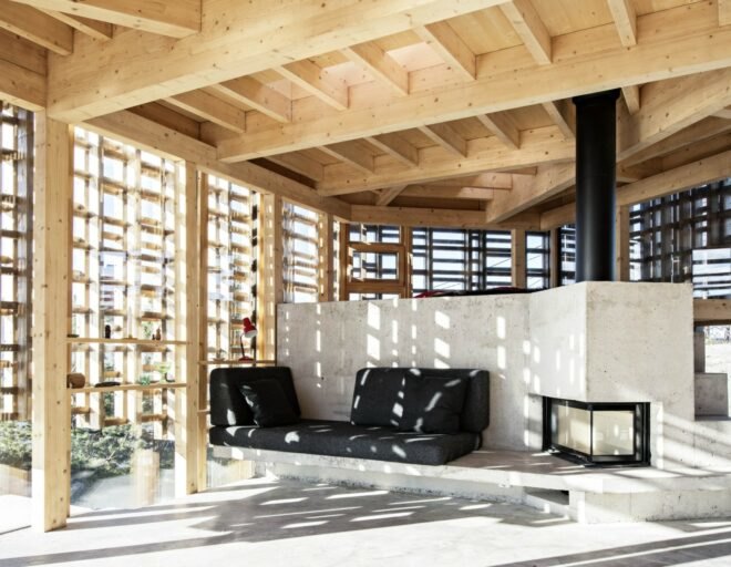 interior living space with wooden beams, concrete flooring, and large concrete fireplace