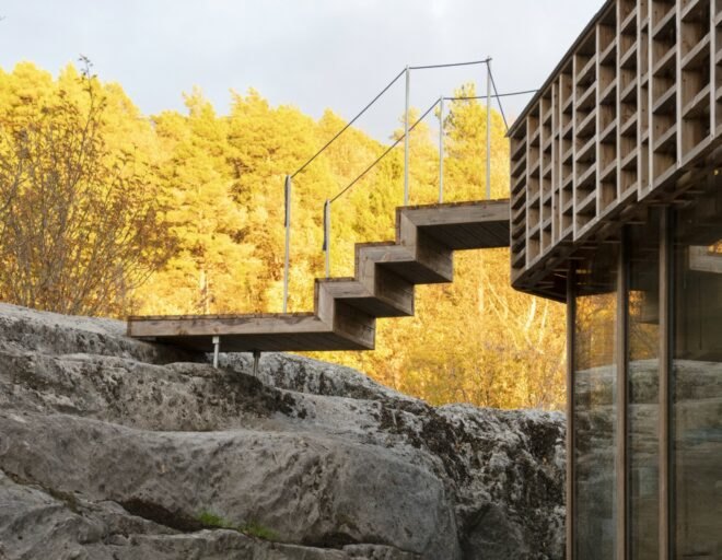 home with metal staircase leading to rocky landscape