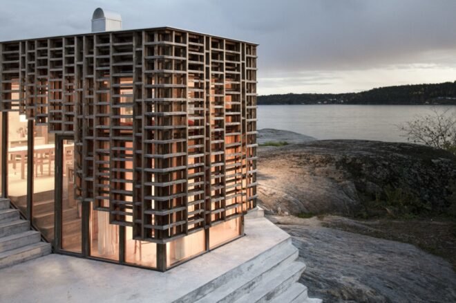 home wrapped in timber slats lit up at dusk