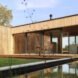 timber home lined with grass and a nearby natural pool