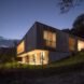 the home illuminated with lights in the evening