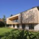 timber home lined with grass and a nearby pond