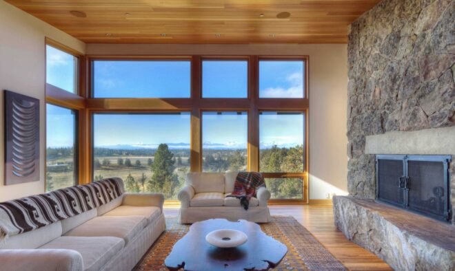 floor to ceiling windows in living room area with tan colored couched