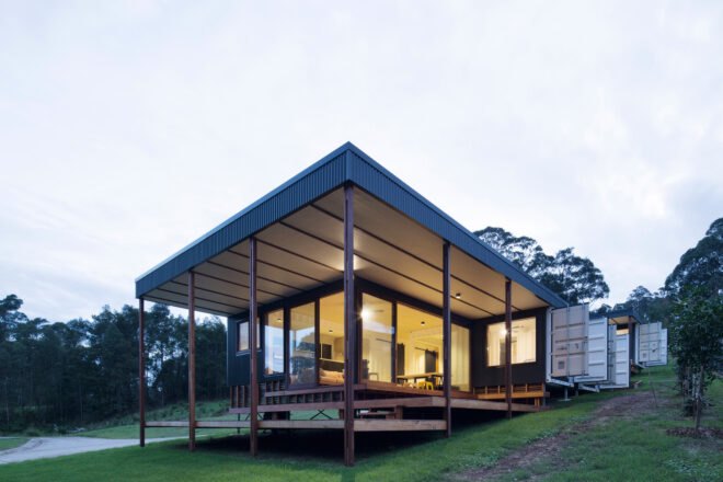 shipping container turned into a home with large windows and a deck