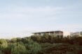 SDE4 sits atop a hill of greenery surrounded by trees