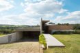 brick home with large vertical panel separating the home from the garage