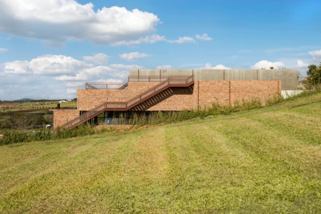 brick home with outdoor staircase leading to roof