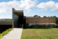 brick home with large vertical panel separating the home from the garage