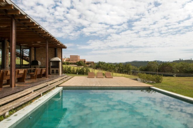 brick home with swimming pool and wood deck
