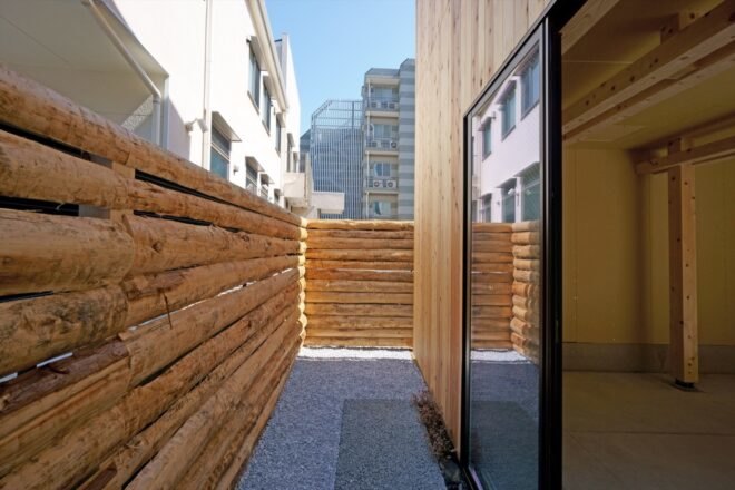 sliding glass doors leading to small outdoor area with log fence