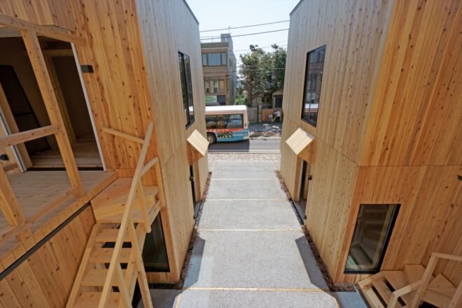 bus driving by twin wood buildings