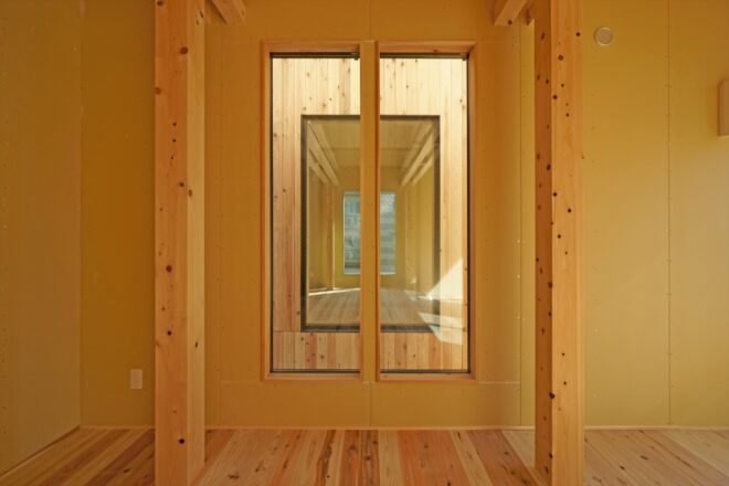 room with wood floors, tan walls and two tall windows