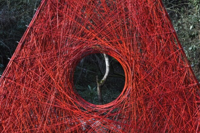 close-up of circular opening in red woven carbon fiber