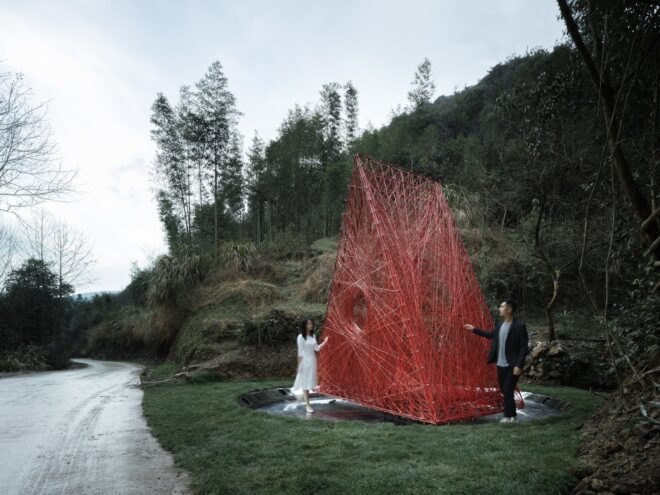 woman standing next to red triangular structure