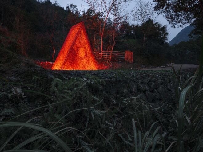 red triangular structure lit up at night