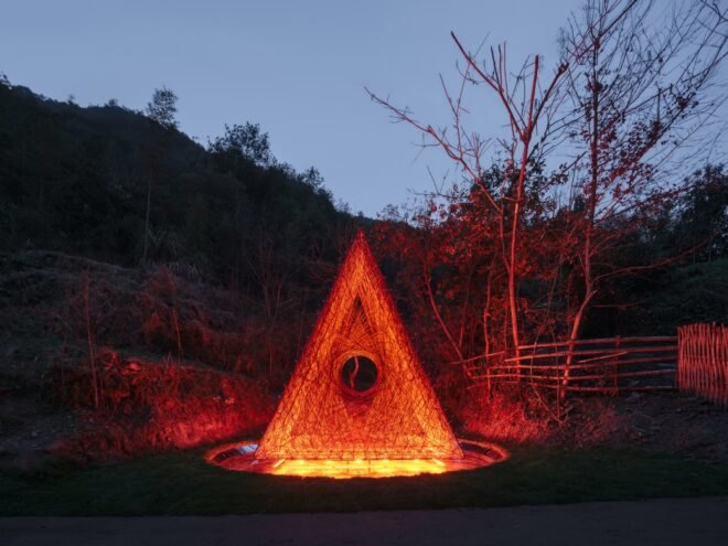 red triangle structure in the countryside lit up at night