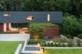 gray and wood home with green roof and gardens