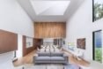 white room with gray couch, white dining table and white kitchen