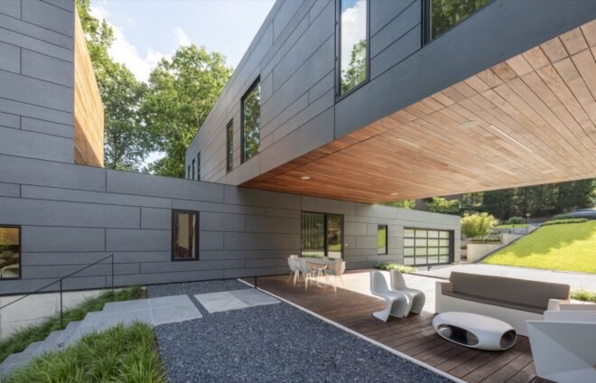 gray perpendicular volumes that form a covered outdoor patio