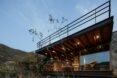 cabin with glass facade and rooftop terrace at dusk