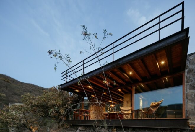 cabin with glass facade and rooftop terrace at dusk
