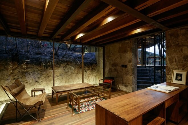 wood and stone cabin interior with chairs around a coffee table