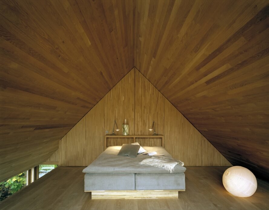 pyramid style bedroom with wooden walls shaped into a pyramid near the bed's headboard