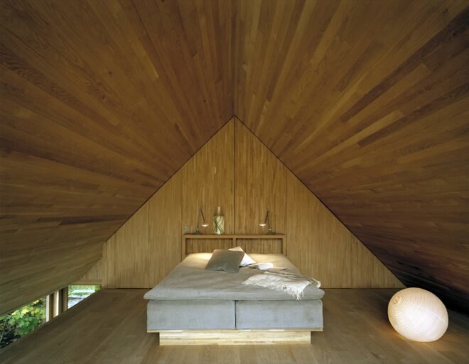 pyramid style bedroom with wooden walls shaped into a pyramid near the bed's headboard