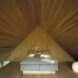 pyramid style bedroom with wooden walls shaped into a pyramid near the bed's headboard
