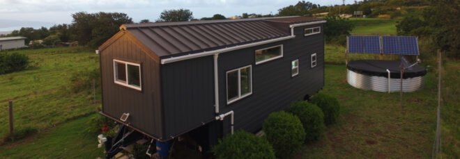 a tiny home clad in dark panels