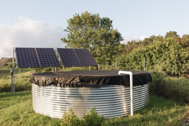 a large water tank with solar panels behind it