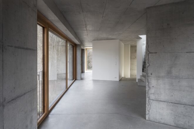 interior of home with concrete walls and large windows