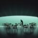 person setting tables in front of window with views of underwater