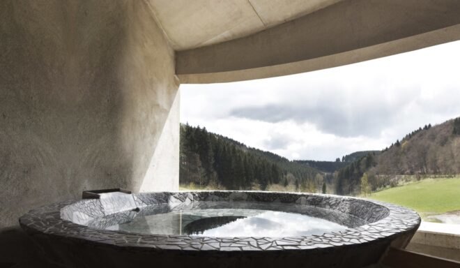 round hot tub on deck facing mountainous landscape