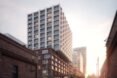 white tower building with concave apartment windows on top of old brick building