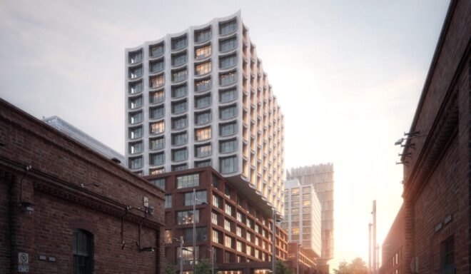 white tower building with concave apartment windows on top of old brick building