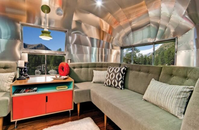 gray sofa and wood and red table inside an Airstream