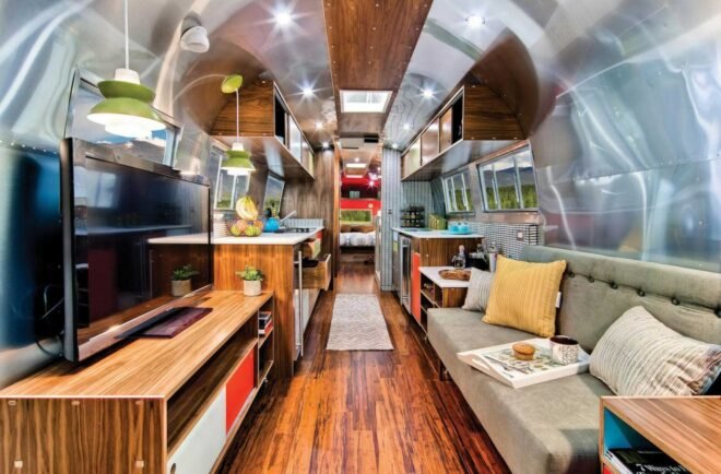 Airstream interior with gray sofa and wood TV stand